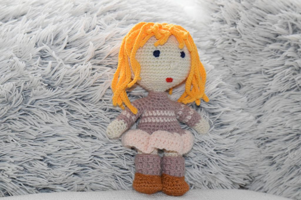 Lalka ze złotymi włosami na szydełku.